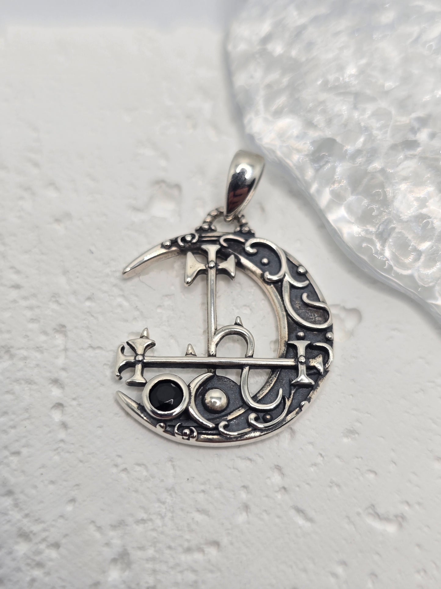 Invoke independence, intuition, and lunar mystery with the Lilith Moon Sigil Pendant, crafted in solid 925 sterling silver. A crescent moon frames Lilith’s sigil in elegant openwork, while a black gemstone at the centre adds bold contrast and dark, celestial allure. Light plays through the cutout detailing, giving the piece an ethereal, night-sky presence.
Wear it as a personal emblem of empowerment or gift it to someone who loves moon magic, folklore, and symbolic jewellery—this pendant is equal parts sta