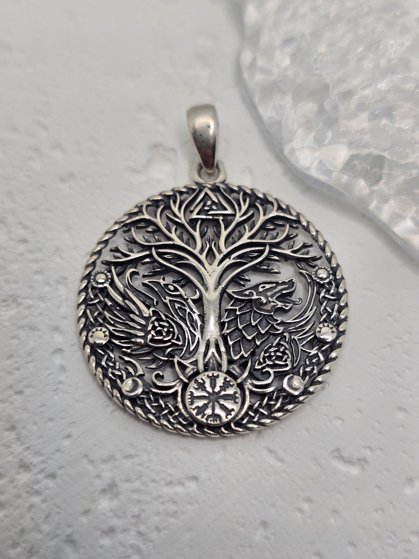 Honor ancient lore and powerful symbols with the Viking Raven Wolf Yggdrasil Pendant, crafted in solid 925 sterling silver. Centered on Yggdrasil—the Norse Tree of Life—this design unites the raven (wisdom, knowledge) and the wolf (strength, guardianship) around interlacing motifs, celebrating connection, courage, and timeless heritage.
Wear it as a daily talisman or gift it to a lover of Norse mythology—crisp engraving and a polished finish give this piece a striking, meaningful presence.
Key Features: