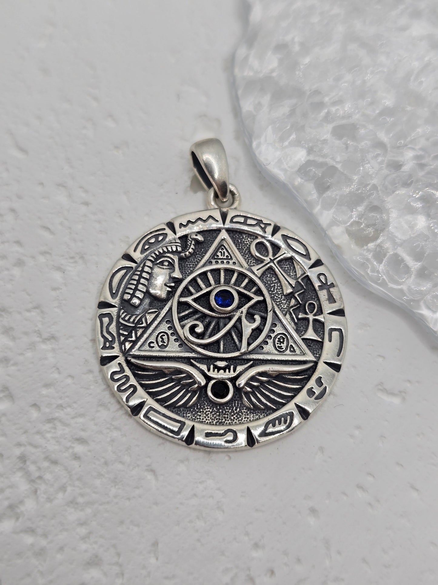 Unlock ancient insight and royal symbolism with this Egyptian Pyramid & All-Seeing Eye Pendant, crafted in solid 925 sterling silver and set with a captivating lapis lazuli at the centre. The eye within a triangle evokes enlightenment and protection, while surrounding motifs—pyramid, wings of Horus, and hieroglyphic accents—create a richly detailed medallion that blends history, mystery, and style.
Wear it as a conversation-starting talisman or gift it to a lover of ancient cultures and esoteric design