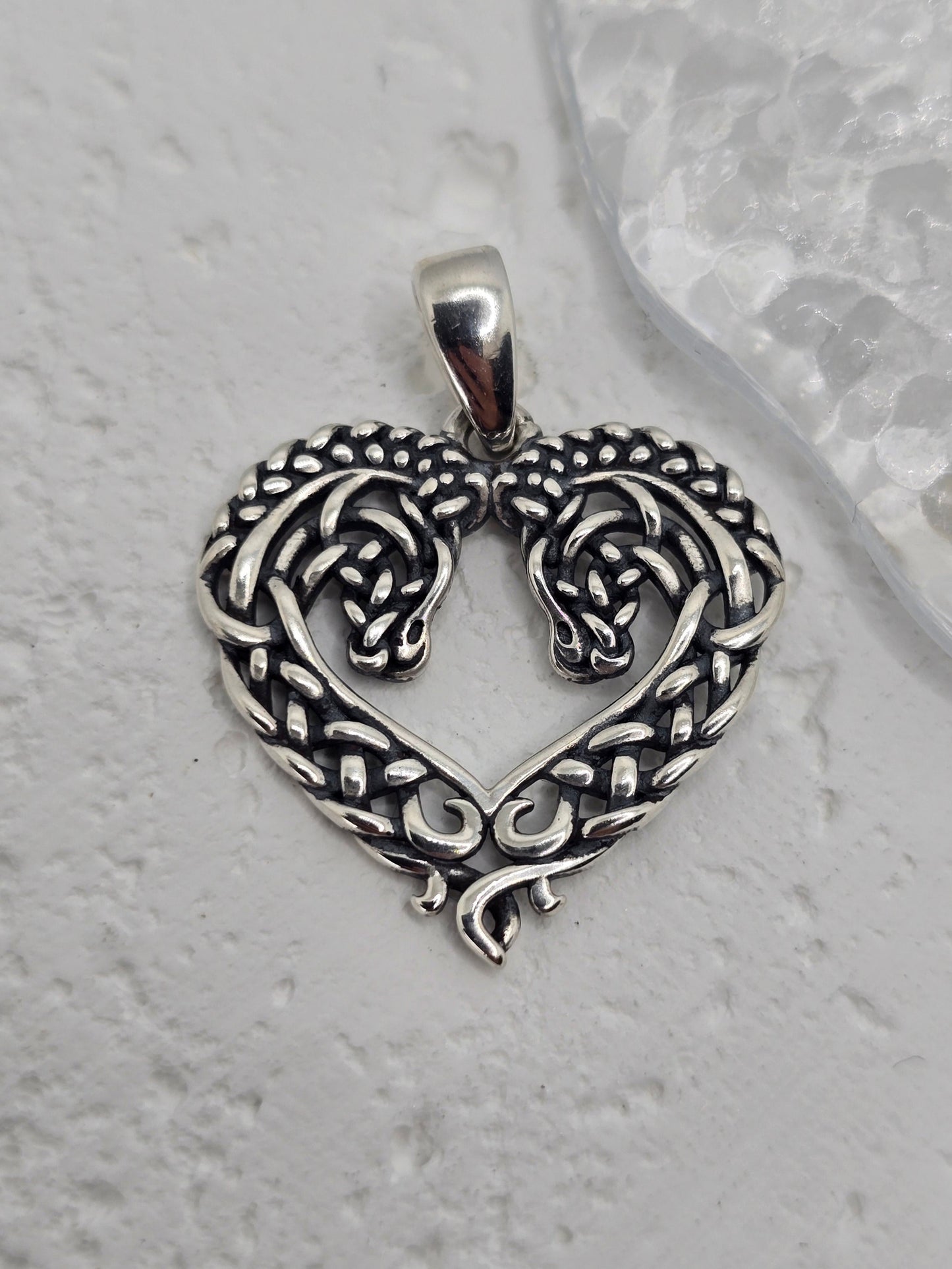 Celtic Horse Heart Knot in 925 Sterling Silver
Celebrate love, loyalty, and heritage with this Celtic Horse Heart Knot pendant, crafted in 925 sterling silver. A heart-shaped design intertwines with Celtic knotwork, culminating in twin horse heads—a graceful tribute to companionship and the free spirit of the horse.
Design & Symbolism
Heart Knot: Symbol of love, unity, and enduring affection.
Twin Horse Heads: Represents companionship, loyalty, and a free spirit.
Celtic Knotwork: Endless loo