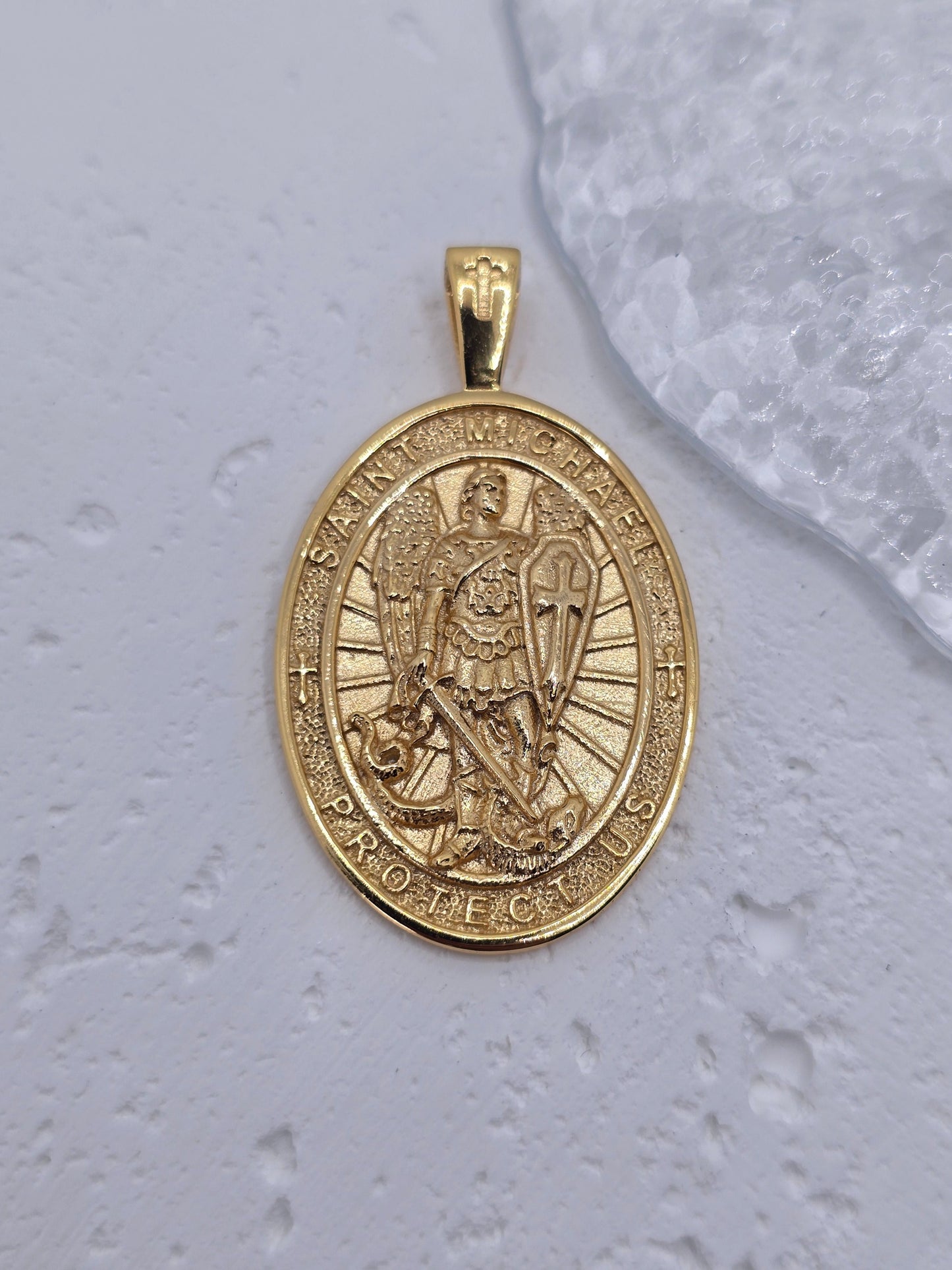 Experience the strength of divine guardianship with this powerful Saint Michael Guardian Archangel Pendant, meticulously crafted in 925 sterling silver and richly enhanced with 18K gold plating. More than just jewelry, this medal is a symbol of protection, bravery, and spiritual victory over darkness.
At the heart of the pendant stands St. Michael the Archangel, the heavenly warrior known for shielding souls from evil and leading the army of light. Clad in armor, sword raised and shield in hand, he represe