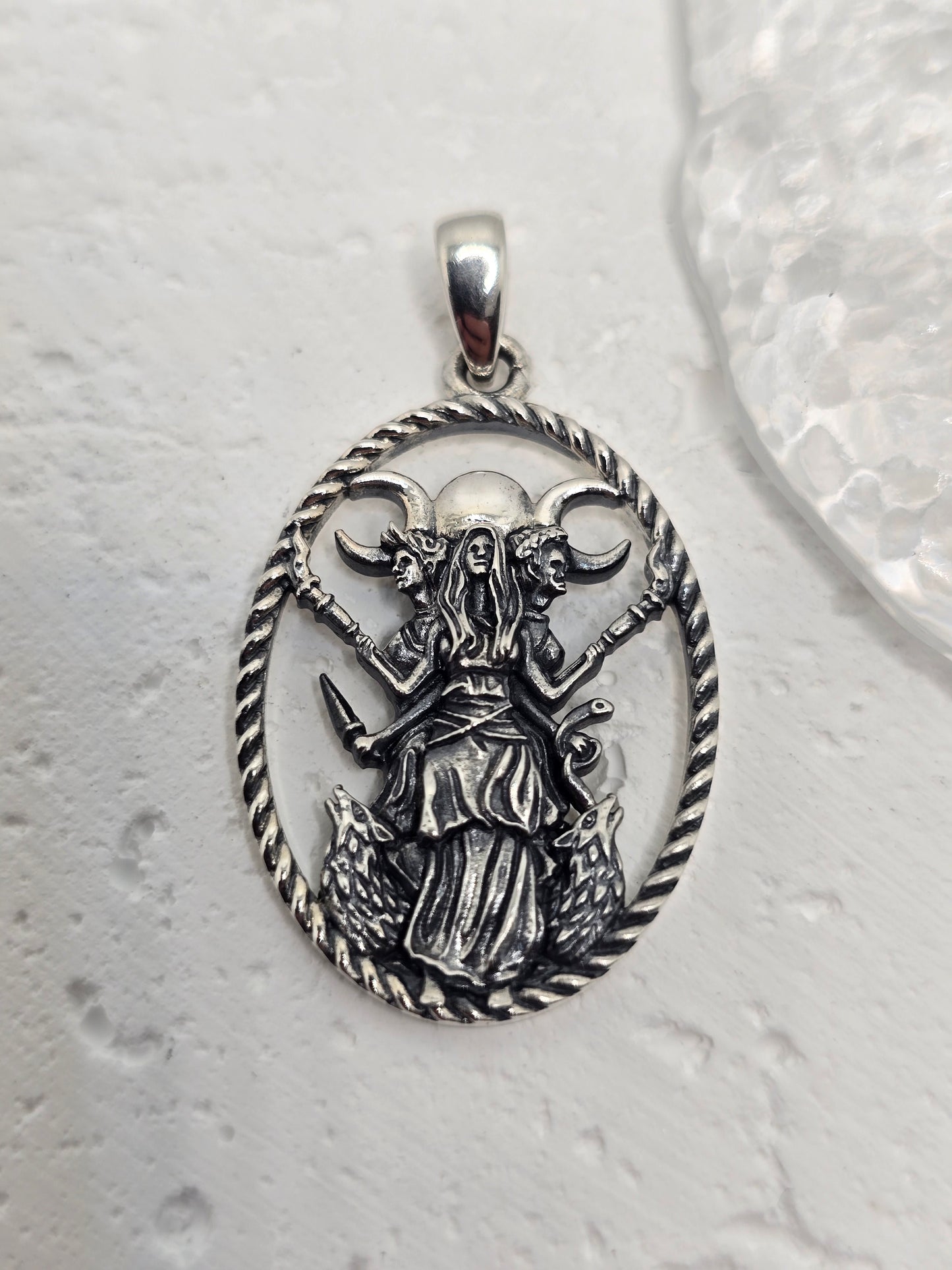 Honor lunar magic, protection, and transformation with the Triple Moon Goddess Hecate Pendant, crafted in luminous 925 sterling silver. Hecate—guardian of thresholds and guide through transitions—stands with her loyal hounds beneath the Triple Moon (Maiden, Mother, Crone), a timeless emblem of the divine feminine and the rhythms of nature.
Intricate detailing captures Hecate’s calm strength and watchful presence, while celestial accents evoke night-sky sparkle. Wear this amulet for guidance, intuition, and