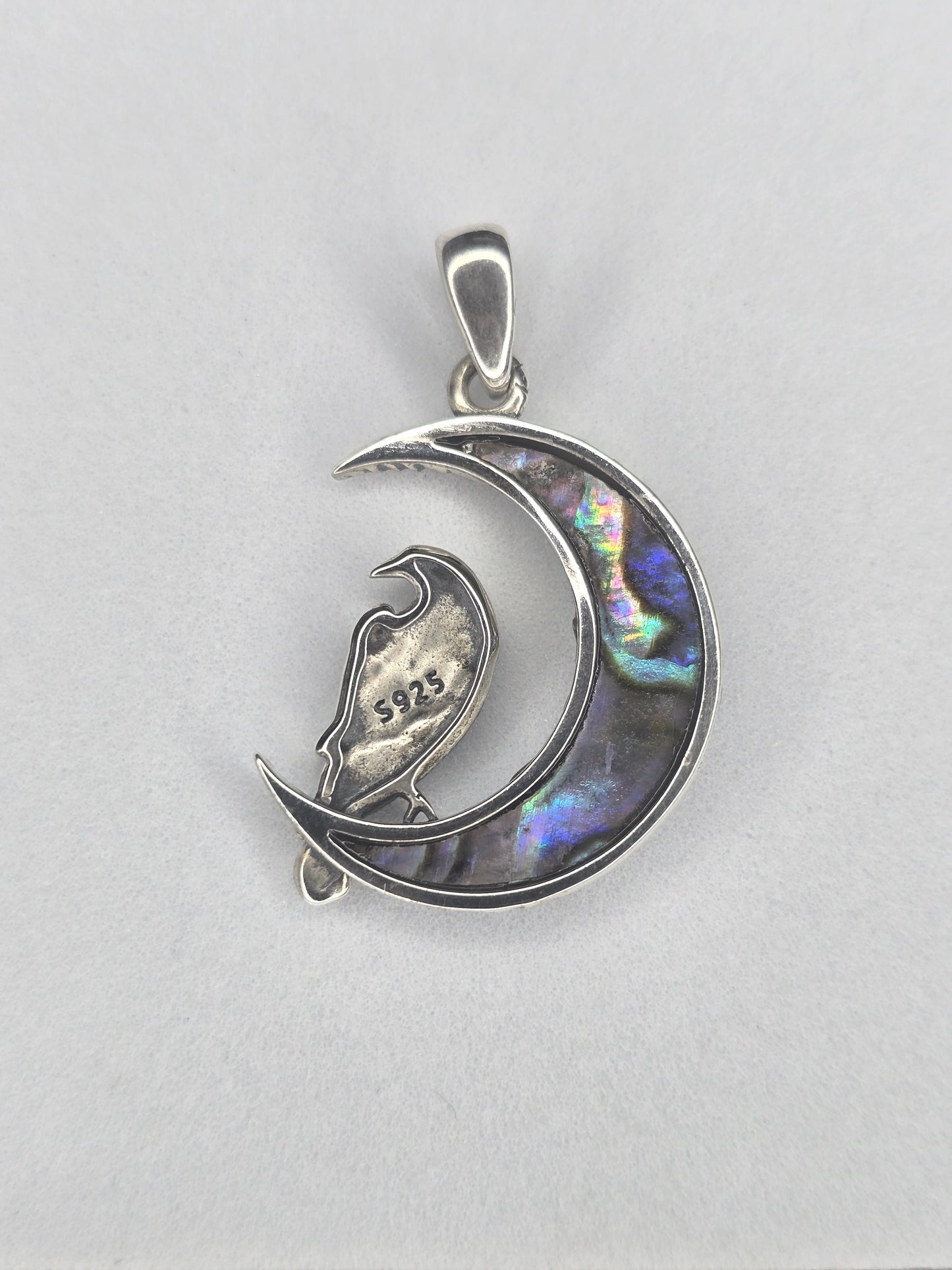 Back view of sterling silver raven moon amulet with abalone shell crescent