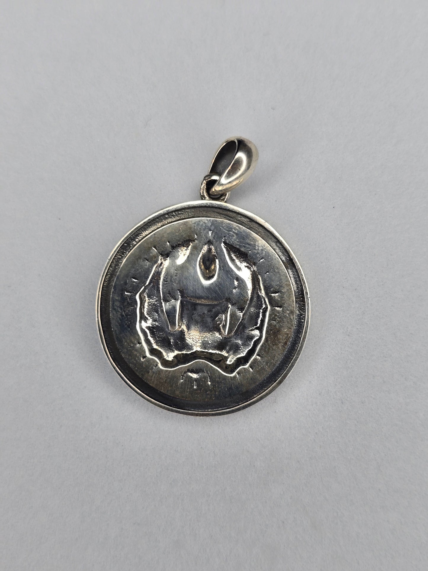 Rear view of oxidised sterling silver Odin pendant with textured back