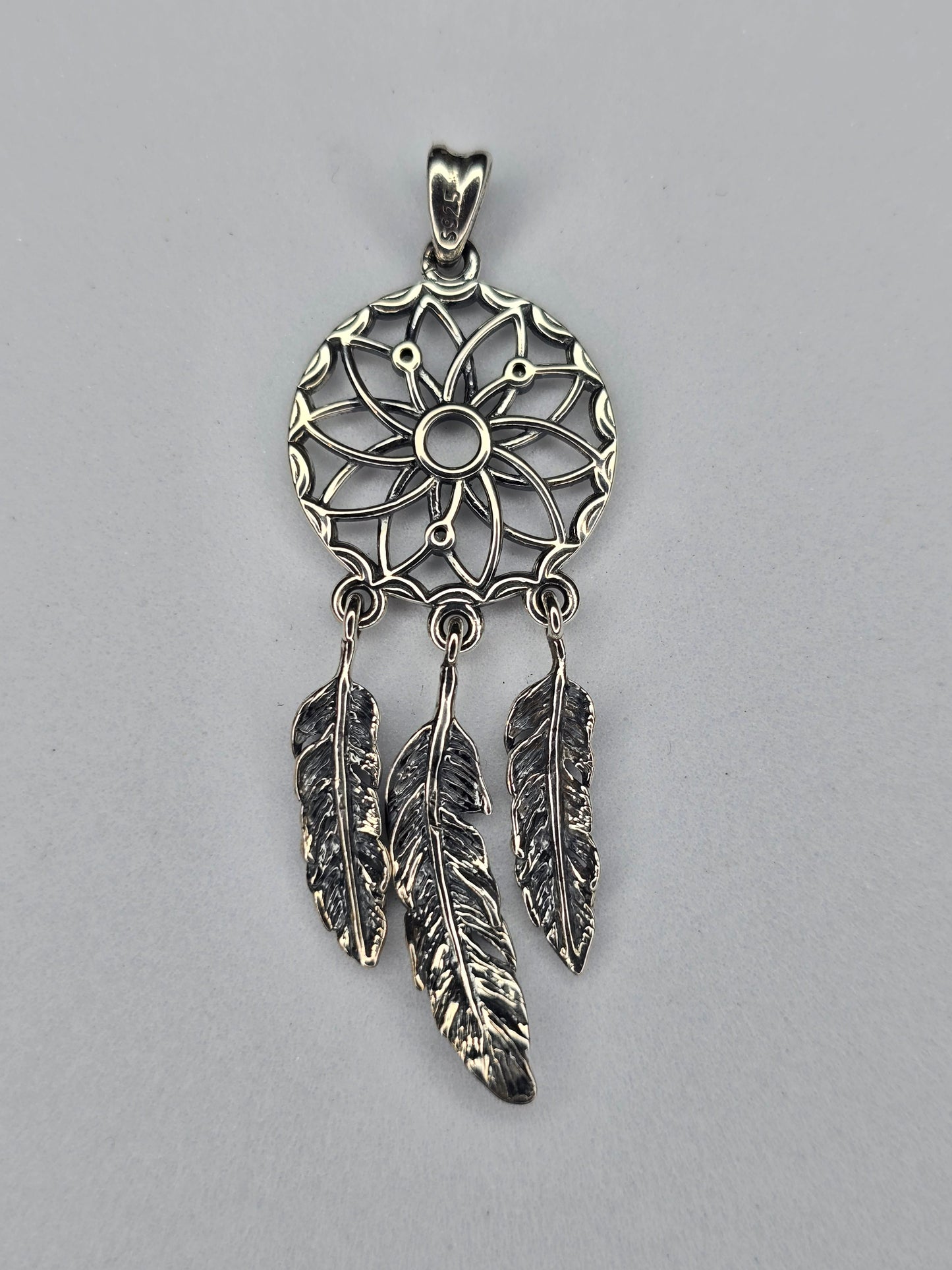 Back view of sterling silver dream catcher pendant with feather details and hallmark