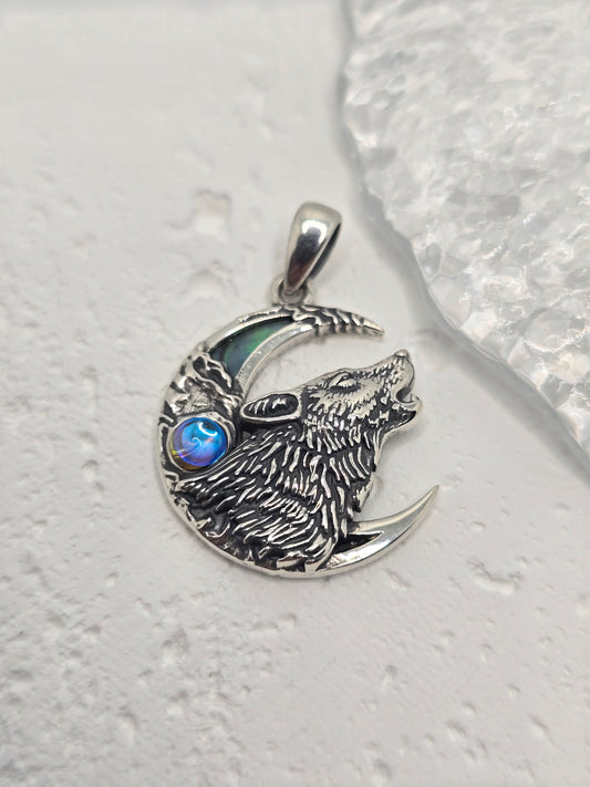 Call on lunar magic and wild intuition with the Wolf &amp; Moon Pendant, crafted in luminous 925 sterling silver and set with an iridescent abalone shell crescent. A finely detailed wolf howls against the night-sky backdrop, celebrating guidance, freedom, and the quiet power of the wild.

Wear it as a symbol of inner strength or gift it to someone who feels at home under moonlight—this piece blends meaningful symbolism with elegant, everyday style.

Key Features:

Made from high-quality 925 Sterling Silver
