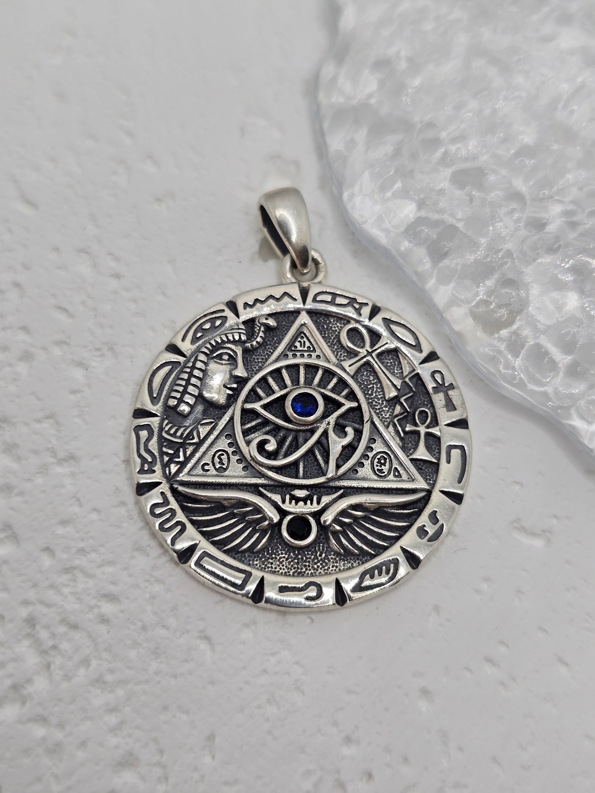 Unlock ancient insight and royal symbolism with this Egyptian Pyramid &amp; All-Seeing Eye Pendant, crafted in solid 925 sterling silver and set with a captivating lapis lazuli at the centre. The eye within a triangle evokes enlightenment and protection, while surrounding motifs—pyramid, wings of Horus, and hieroglyphic accents—create a richly detailed medallion that blends history, mystery, and style.

Wear it as a conversation-starting talisman or gift it to a lover of ancient cultures and esoteric design