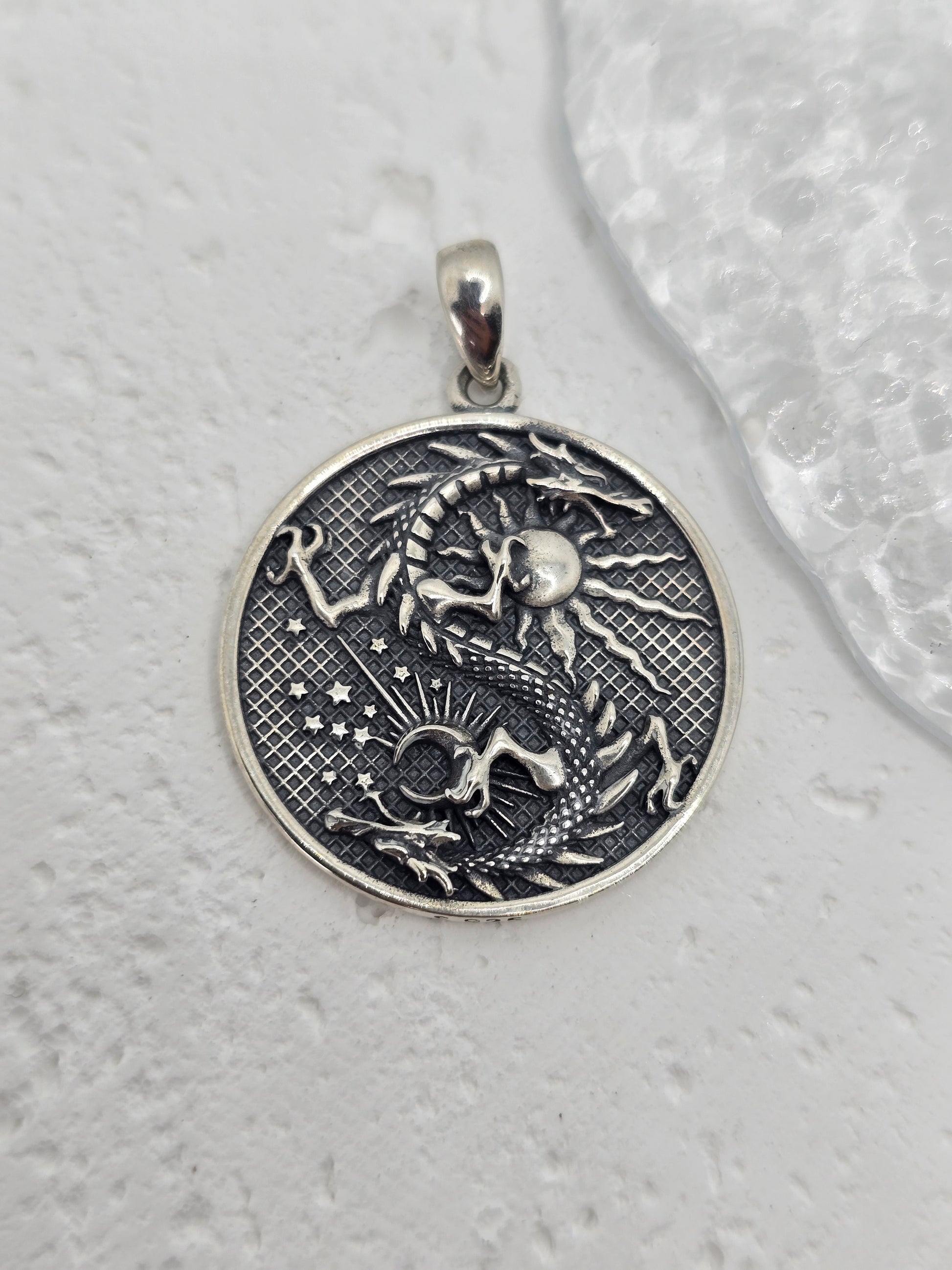 Unleash celestial power with this bold and mystical Moon Dragon Necklace, expertly crafted in 925 sterling silver. This captivating pendant brings together the sun and moon—symbols of duality and cosmic balance—with a majestic dragon, a timeless emblem of strength, transformation, and personal power.

The dragon coils through the sun and moon in an eternal dance, representing the unity of opposites: light and dark, masculine and feminine, action and reflection. The intricate textures and engravings bring th
