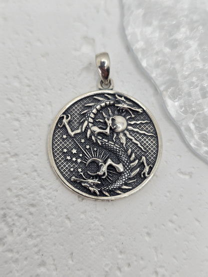 Unleash celestial power with this bold and mystical Moon Dragon Necklace, expertly crafted in 925 sterling silver. This captivating pendant brings together the sun and moon—symbols of duality and cosmic balance—with a majestic dragon, a timeless emblem of strength, transformation, and personal power.

The dragon coils through the sun and moon in an eternal dance, representing the unity of opposites: light and dark, masculine and feminine, action and reflection. The intricate textures and engravings bring th