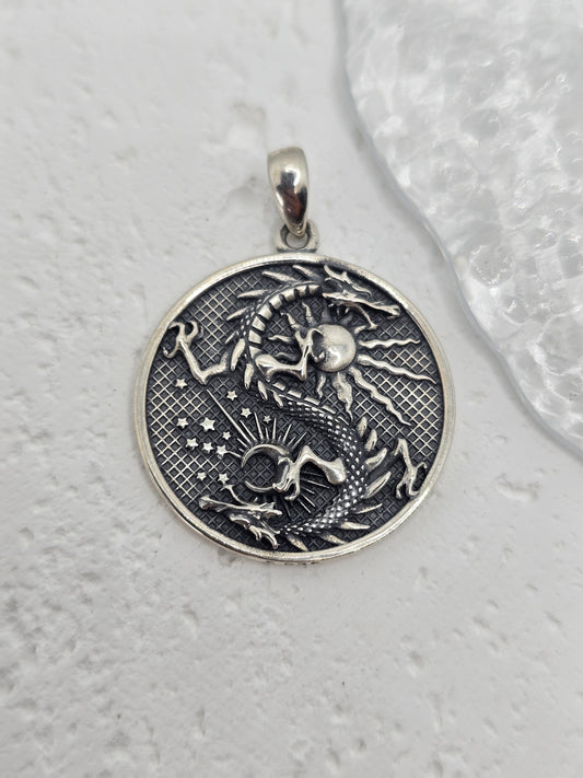 Unleash celestial power with this bold and mystical Moon Dragon Necklace, expertly crafted in 925 sterling silver. This captivating pendant brings together the sun and moon—symbols of duality and cosmic balance—with a majestic dragon, a timeless emblem of strength, transformation, and personal power.

The dragon coils through the sun and moon in an eternal dance, representing the unity of opposites: light and dark, masculine and feminine, action and reflection. The intricate textures and engravings bring th