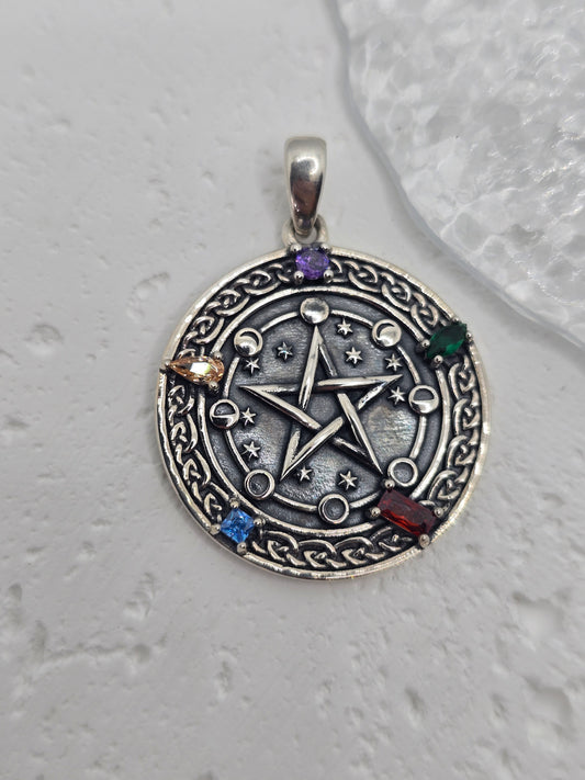 Unlock the power of cosmic energy and elemental balance with this Pentagram Cosmic Cycle Amulet, beautifully crafted from 925 sterling silver and set with vibrant chakra gemstones. This mystical pendant merges the ancient power of the pentagram with the cyclical wisdom of the lunar phases, creating a talisman that protects, empowers, and aligns the spirit.

At the center lies a classic five-pointed star, long revered as a symbol of protection, spiritual knowledge, and harmony between the elements—earth, air