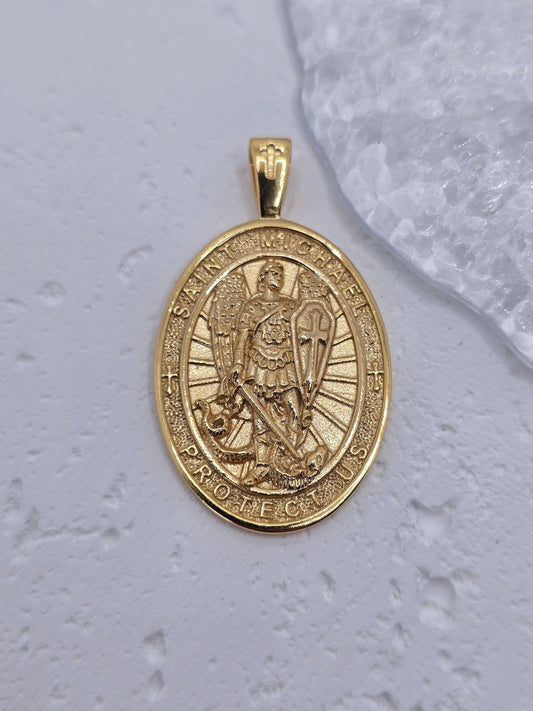 Experience the strength of divine guardianship with this powerful Saint Michael Guardian Archangel Pendant, meticulously crafted in 925 sterling silver and richly enhanced with 18K gold plating. More than just jewelry, this medal is a symbol of protection, bravery, and spiritual victory over darkness.

At the heart of the pendant stands St. Michael the Archangel, the heavenly warrior known for shielding souls from evil and leading the army of light. Clad in armor, sword raised and shield in hand, he represe