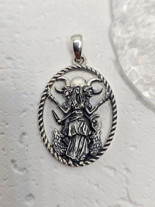 Honor lunar magic, protection, and transformation with the Triple Moon Goddess Hecate Pendant, crafted in luminous 925 sterling silver. Hecate—guardian of thresholds and guide through transitions—stands with her loyal hounds beneath the Triple Moon (Maiden, Mother, Crone), a timeless emblem of the divine feminine and the rhythms of nature.

Intricate detailing captures Hecate’s calm strength and watchful presence, while celestial accents evoke night-sky sparkle. Wear this amulet for guidance, intuition, and