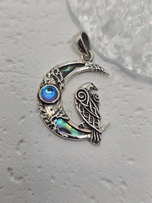 Capture lunar magic and ancient wisdom with the Celtic Raven Pendant, crafted in luminous 925 sterling silver. A prophetic raven perches on a crescent moon inlaid with iridescent abalone shell, while a central moonstone glows with soothing, intuitive energy—evoking night-sky hues and the mystery of folklore.

Wear it as a protective talisman or a meaningful statement of connection to nature, myth, and the moon’s quiet guidance.

Key Features:

Made from solid 925 Sterling Silver
Raven on crescent moon with 