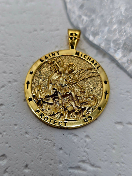 Embrace courage, justice, and protection with the Saint Michael Christian Medallion, crafted in solid 925 sterling silver and finished with 18K gold plating. The front shows Saint Michael the Archangel in high relief, triumphing over evil, encircled by the invocation “Saint Michael Protect Us.” It’s a meaningful talisman and an elegant statement of faith.

On the reverse, sacred Christian symbols appear with the inscription “SADAY THANATOS SABAOTH,” echoing ancient names associated with divine power and saf