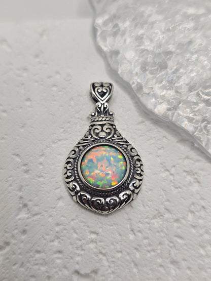 Celebrate timeless romance with this Vintage Style Heart Pendant, masterfully crafted from 925 sterling silver and set with a glowing 2.5ct cabochon opal. With its soft, iridescent shimmer, the opal captures light like a whispered secret, echoing the elegance of a bygone era.

The pendant’s vintage-inspired design features delicate heart motifs and ornate silverwork, making it both a romantic symbol and a bold statement piece. The opal is expertly bezel-set within an intricate frame, polished to a high shin