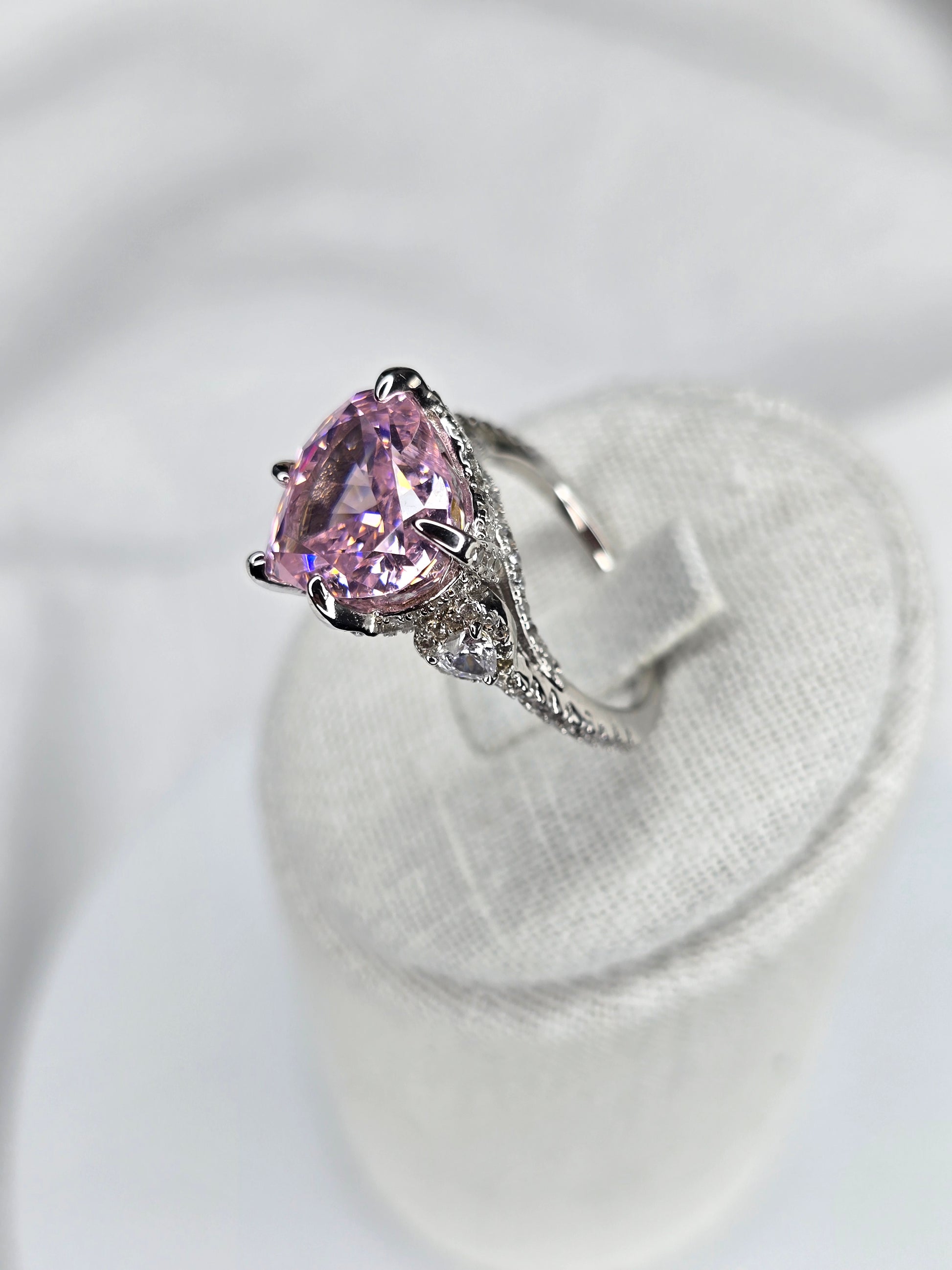 Side view of heart shaped pink moissanite ring with pavé silver band