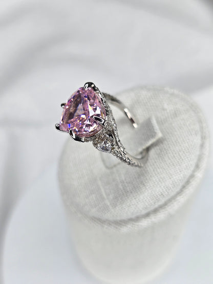 Side view of heart shaped pink moissanite ring with pavé silver band