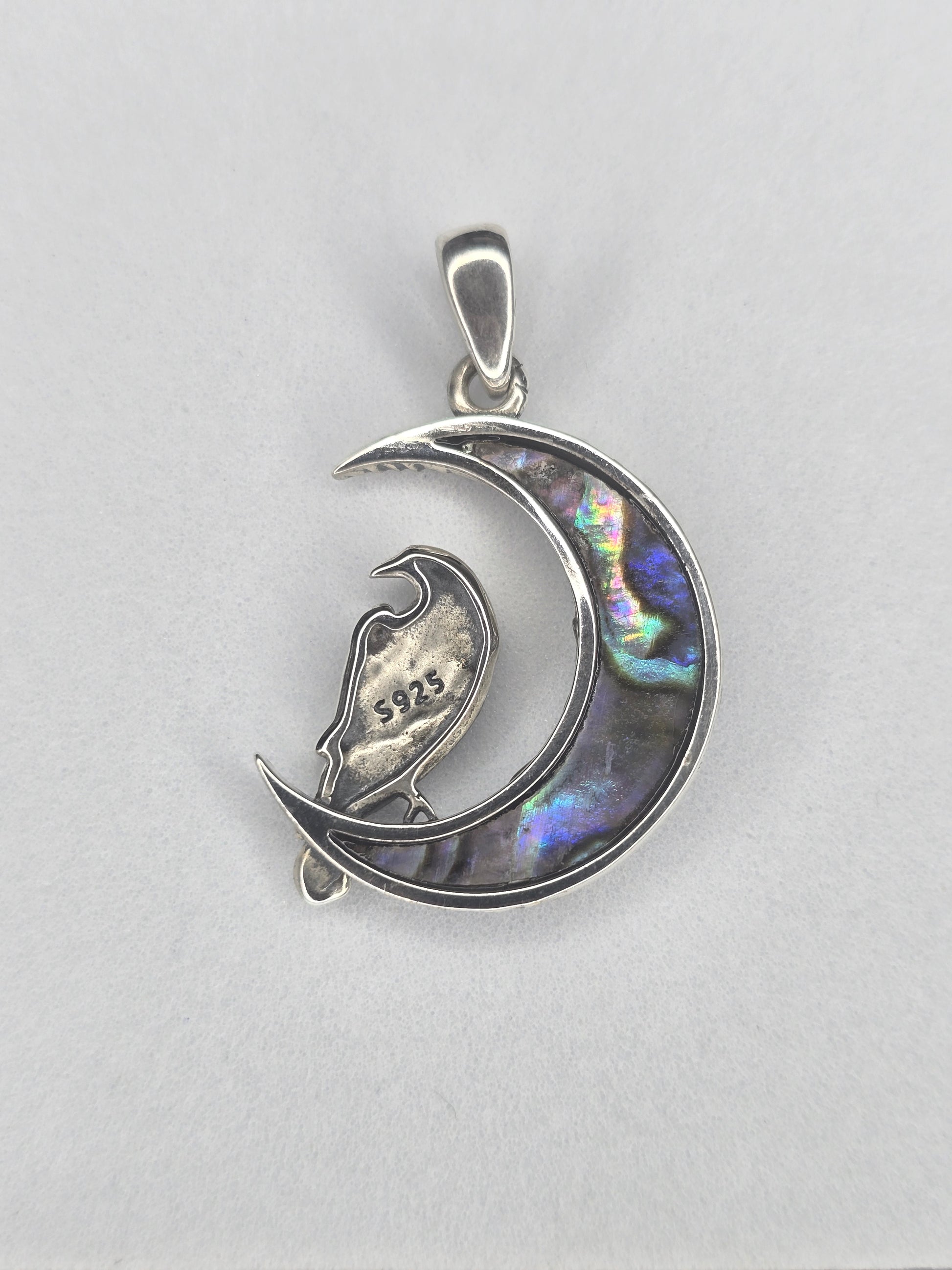Back view of sterling silver raven moon amulet with abalone shell crescent