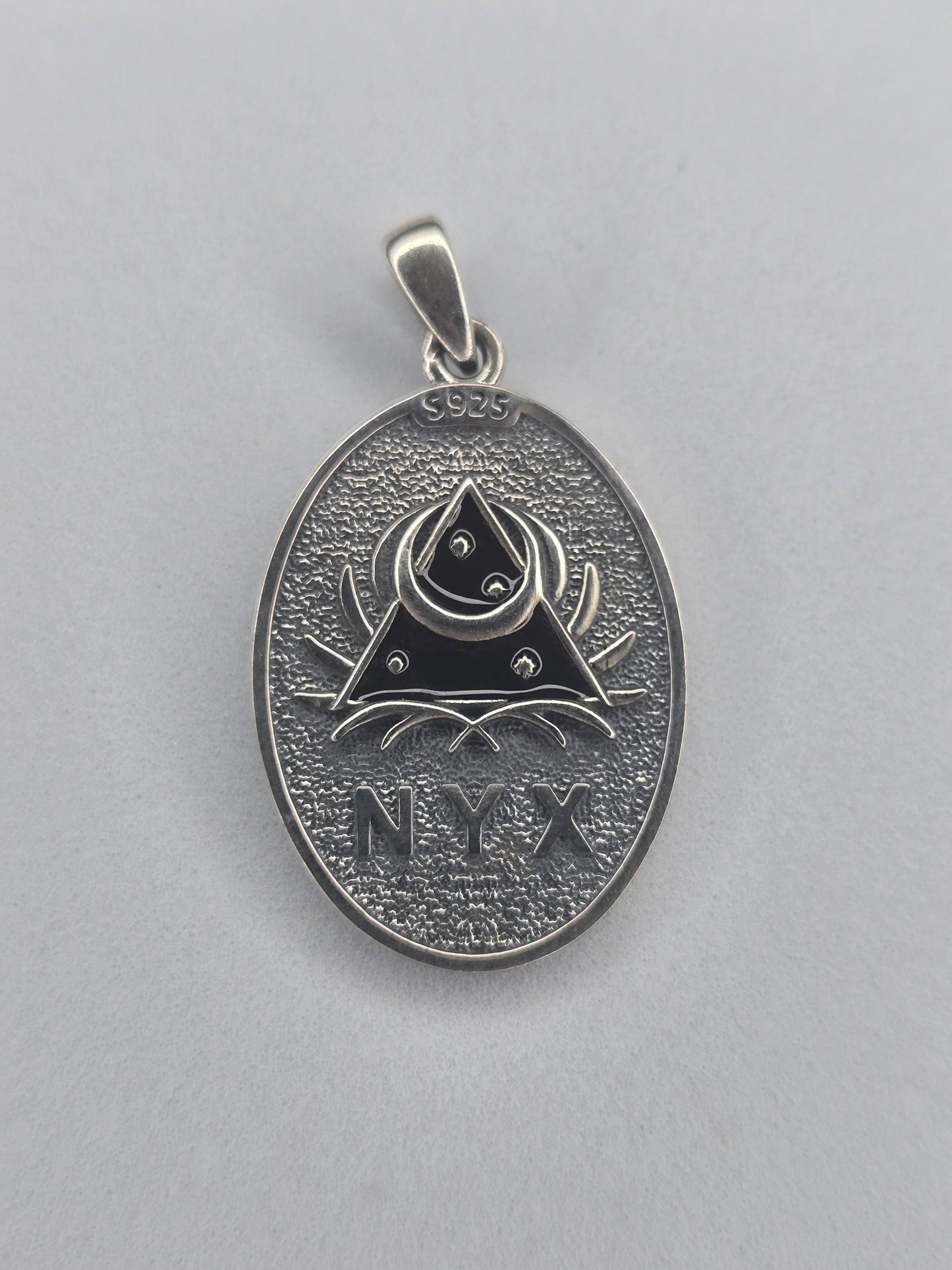 Back view of Nyx pendant with NYX engraving and night symbols
