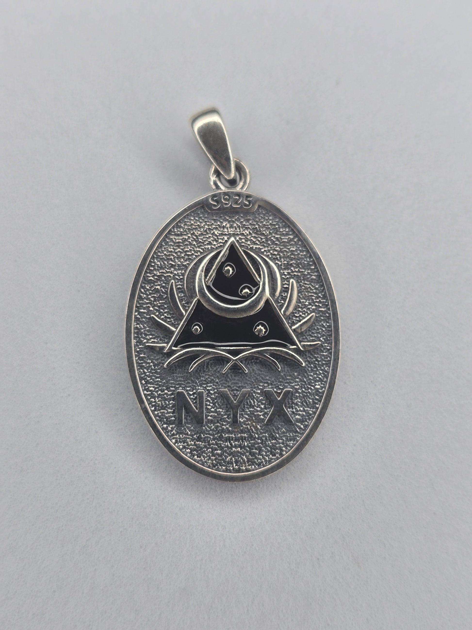 Back view of Nyx pendant with NYX engraving and night symbols