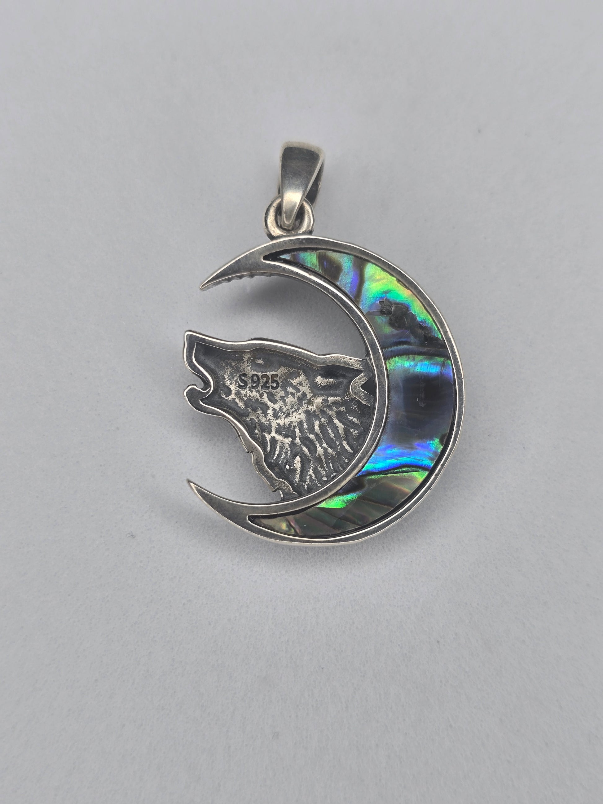 Back view of sterling silver wolf moon pendant with textured finish and 925 hallmark
