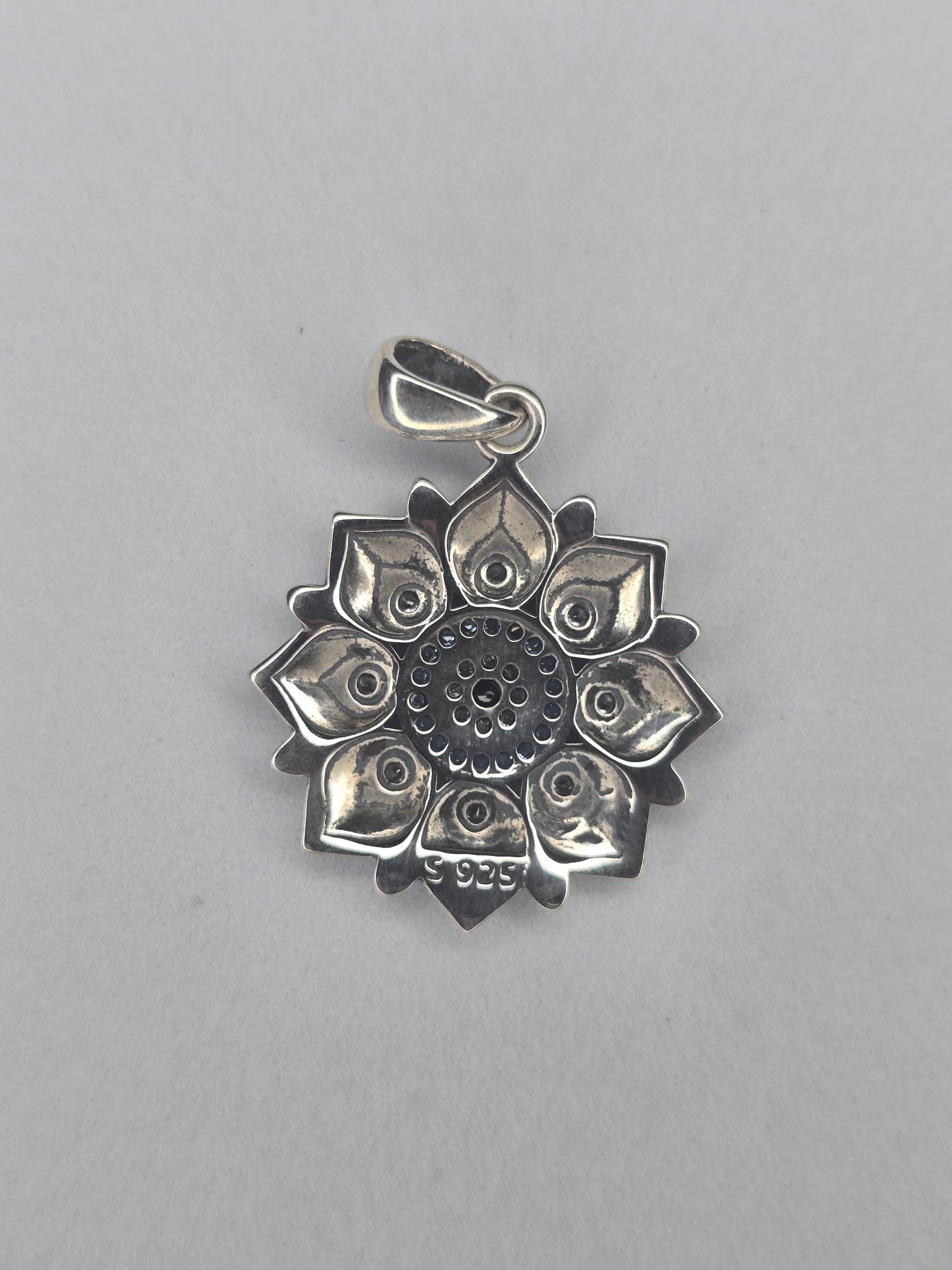 Back view of lotus evil eye pendant in sterling silver showing stamped 925 mark