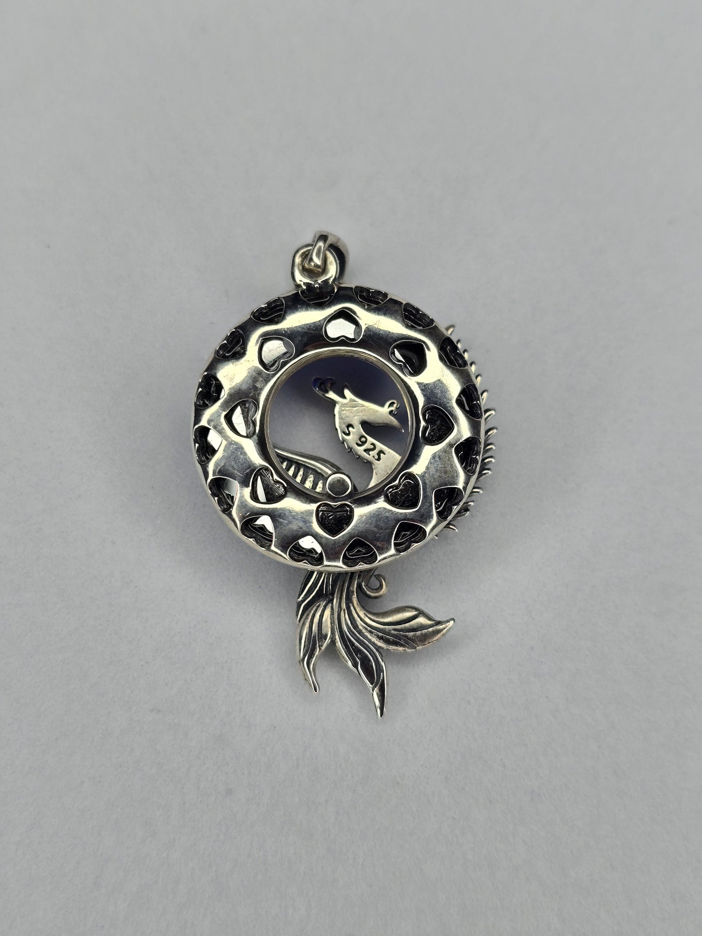 Back view of Phoenix Rising silver pendant with openwork circular frame and phoenix tail detail