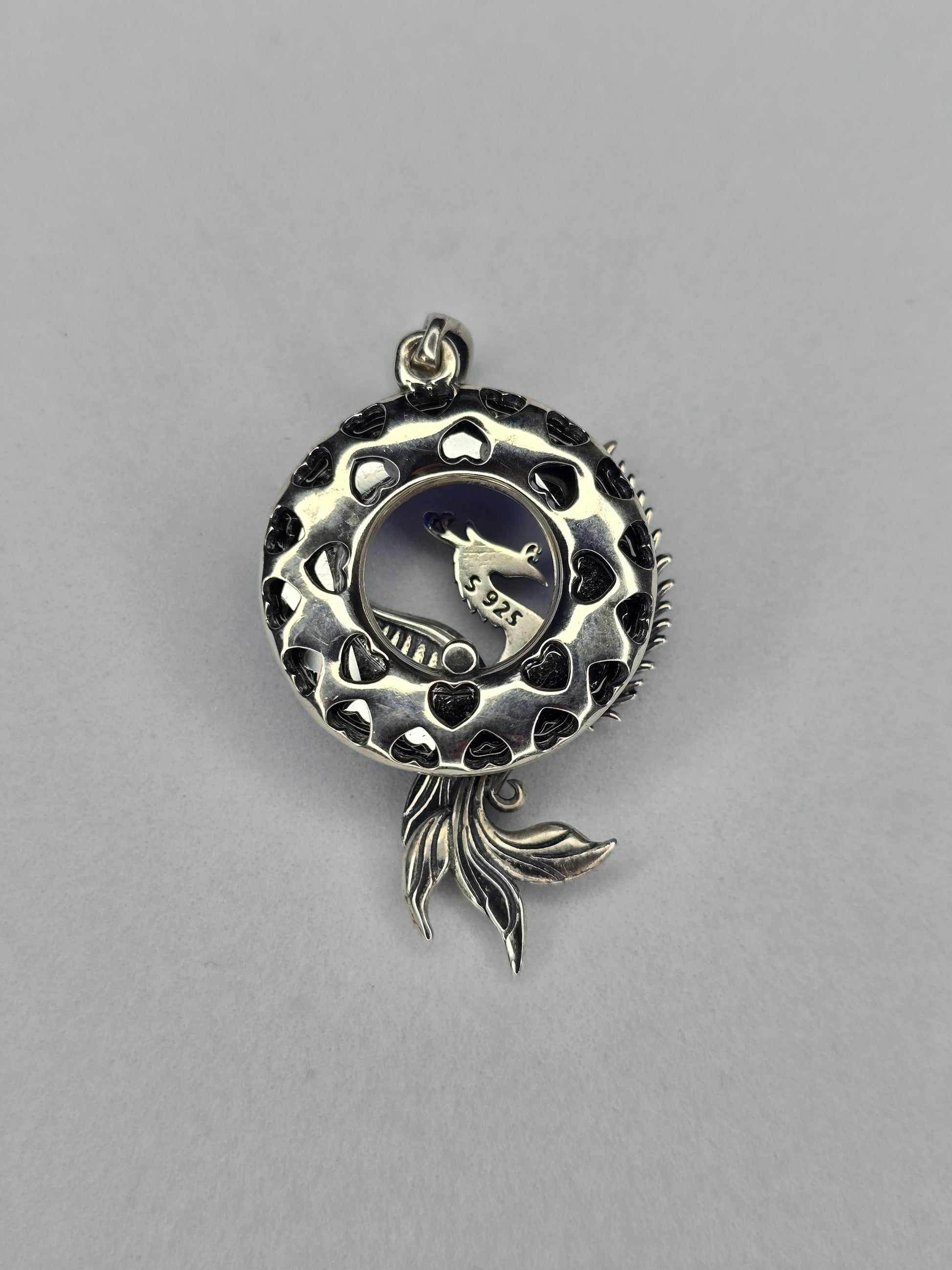 Back view of Phoenix Rising silver pendant with openwork circular frame and phoenix tail detail