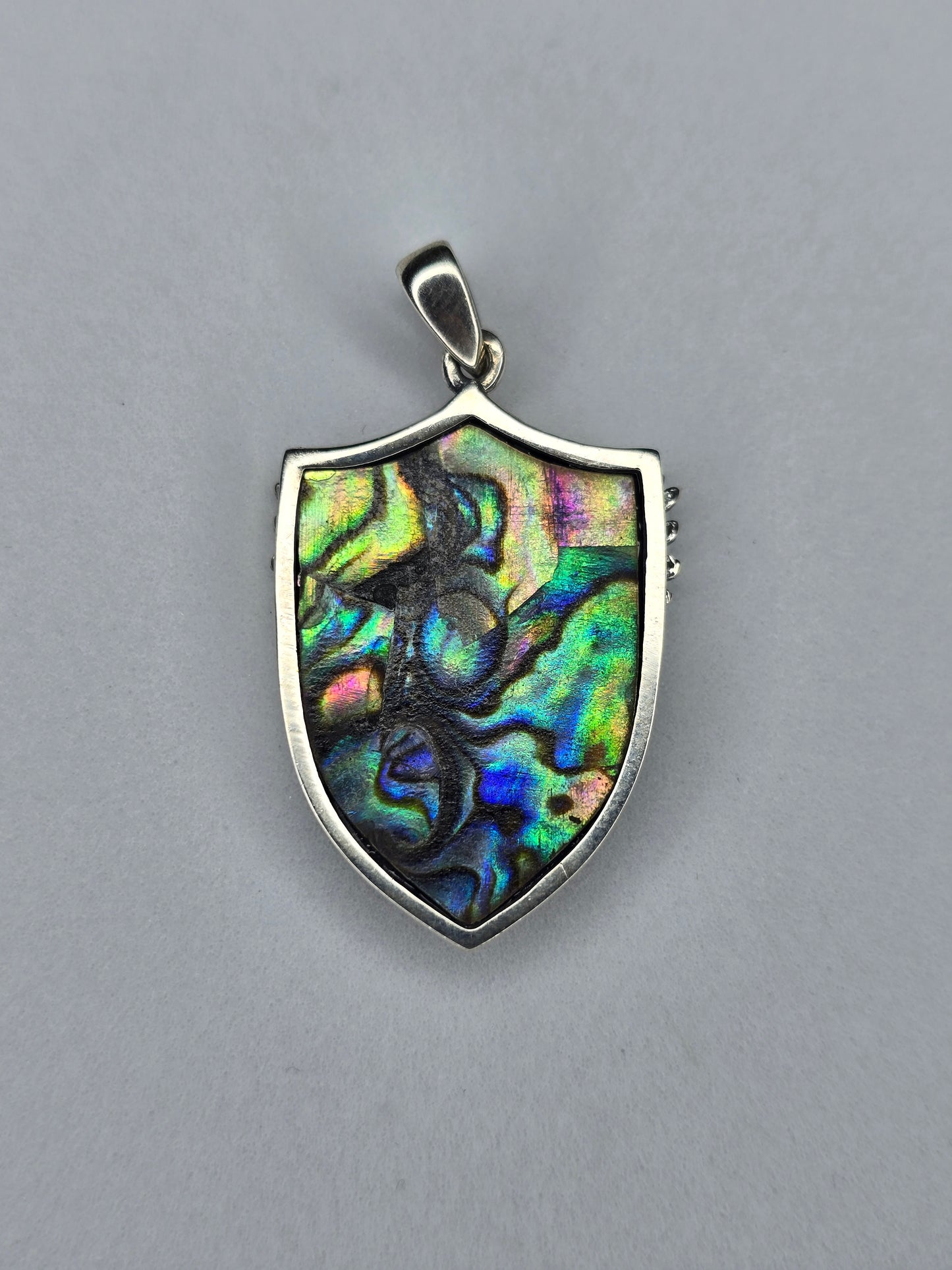 Back view of sterling silver Archangel Michael shield pendant with natural abalone shell and polished frame