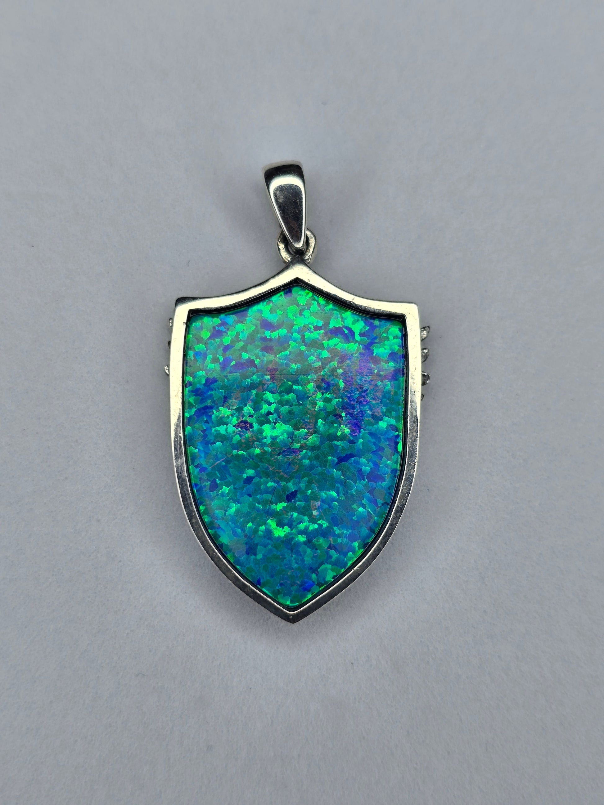 Back view of Saint Michael shield pendant in sterling silver with polished frame and opal inlay