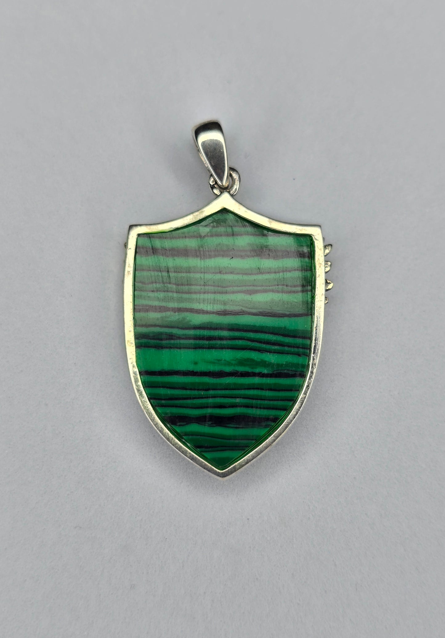 Back view of sterling silver Archangel Michael shield pendant with polished frame and natural malachite stone