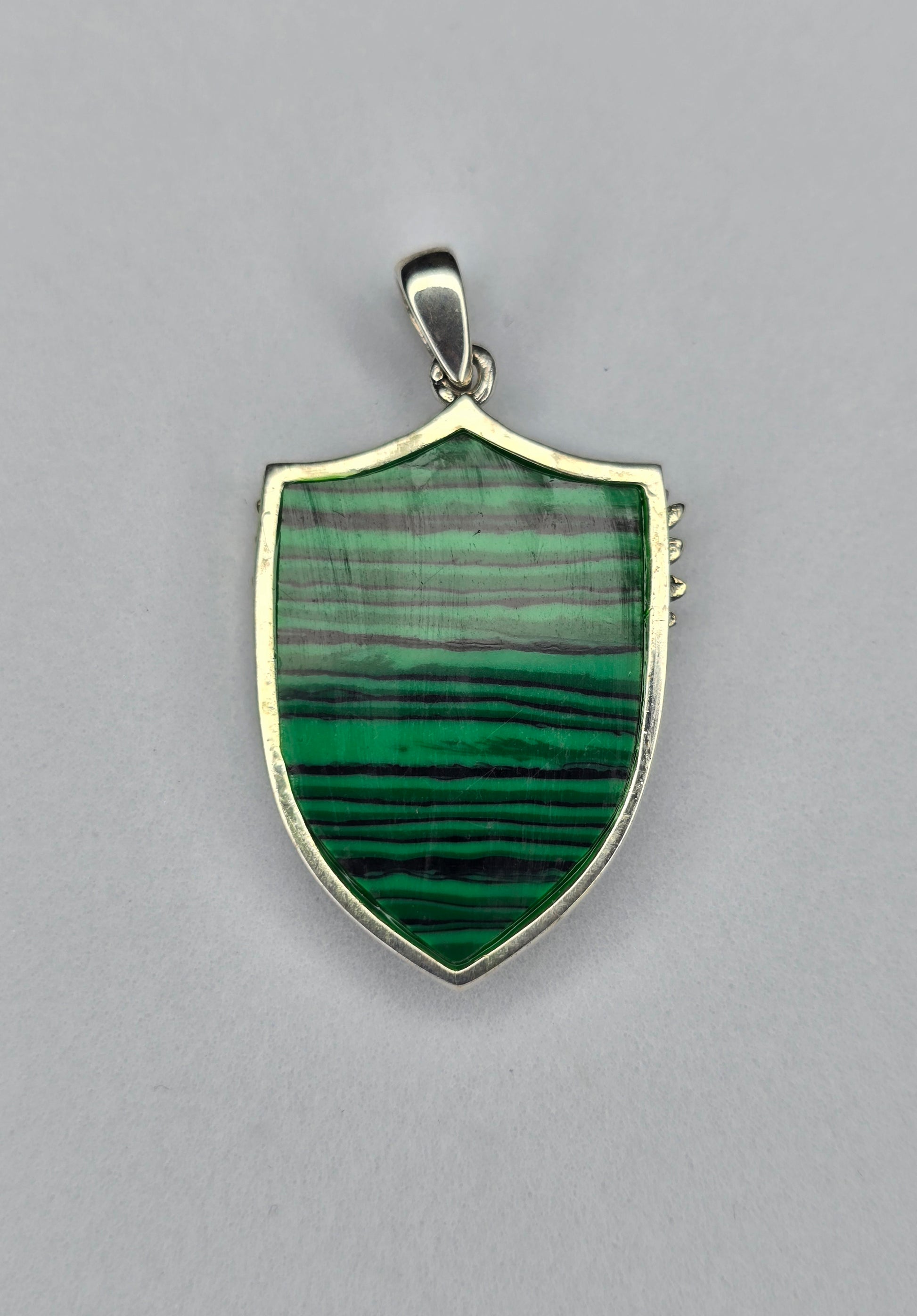 Back view of sterling silver Archangel Michael shield pendant with polished frame and natural malachite stone
