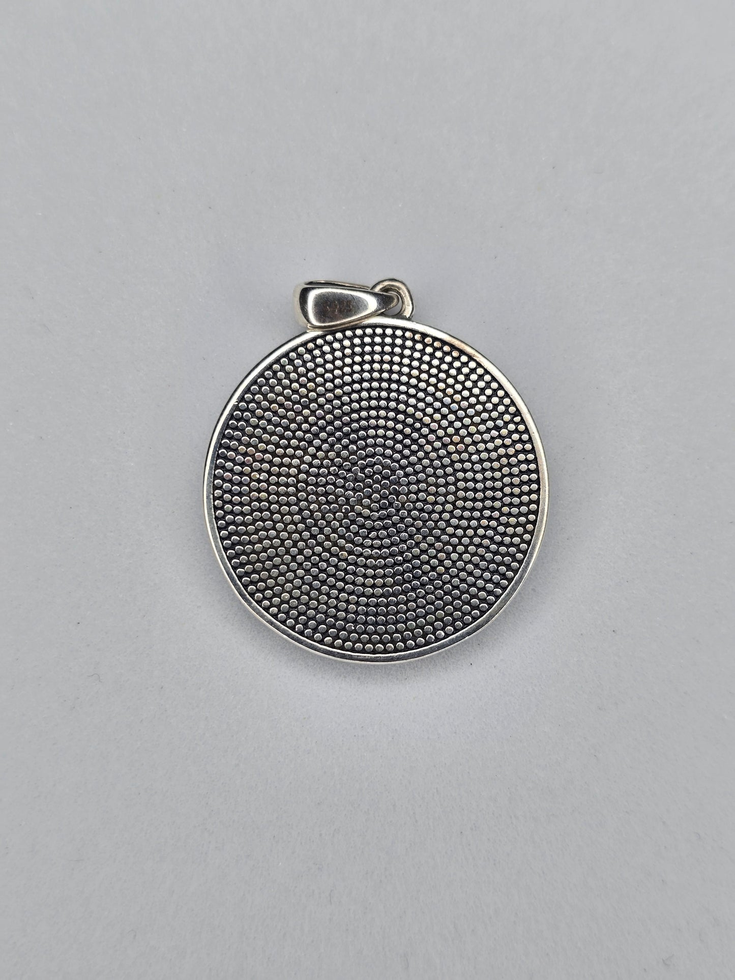 Back view of sterling silver pentagram amulet with textured finish and hallmark