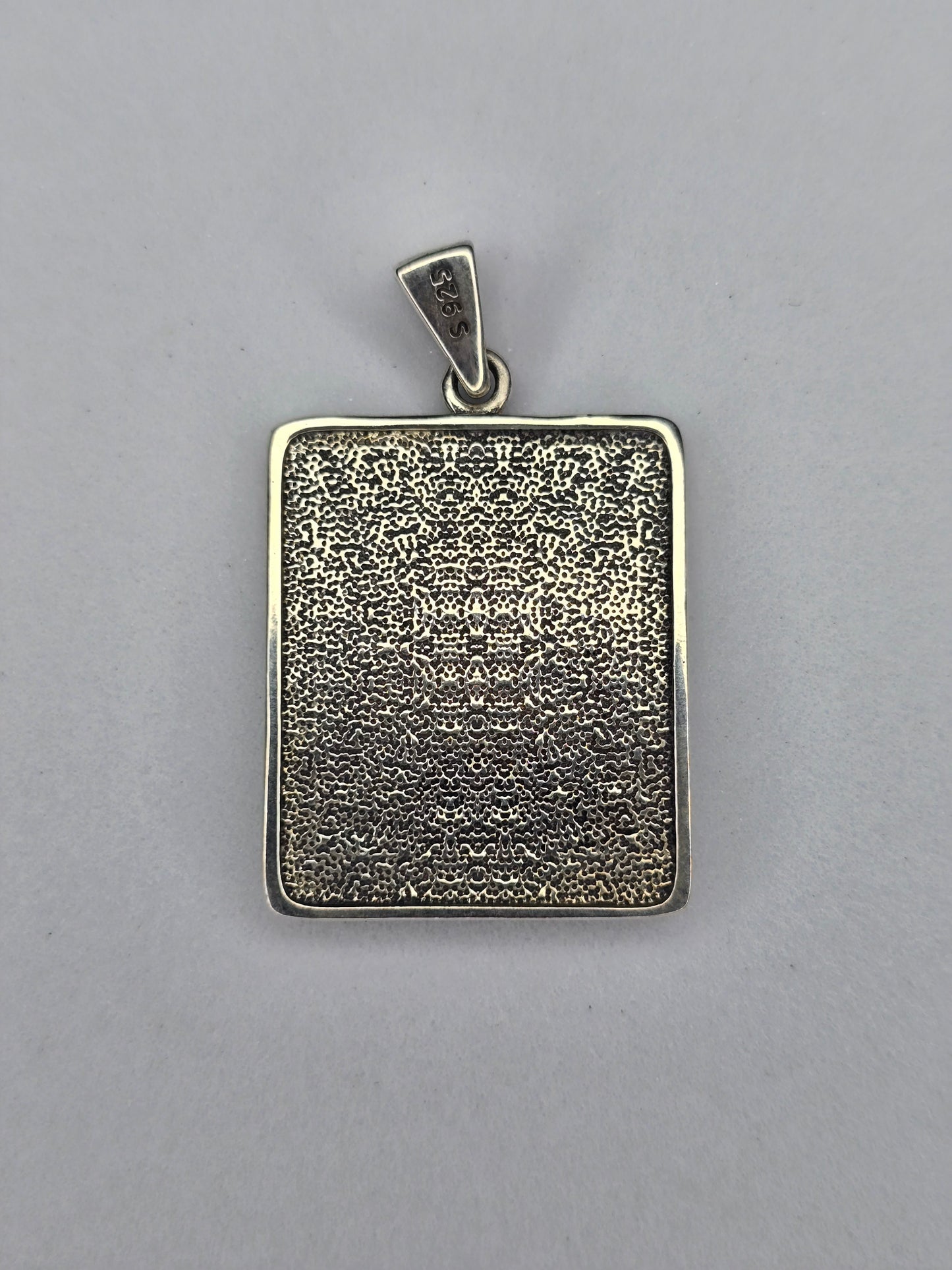 Back view of Saint John silver pendant with textured finish and S925 hallmark