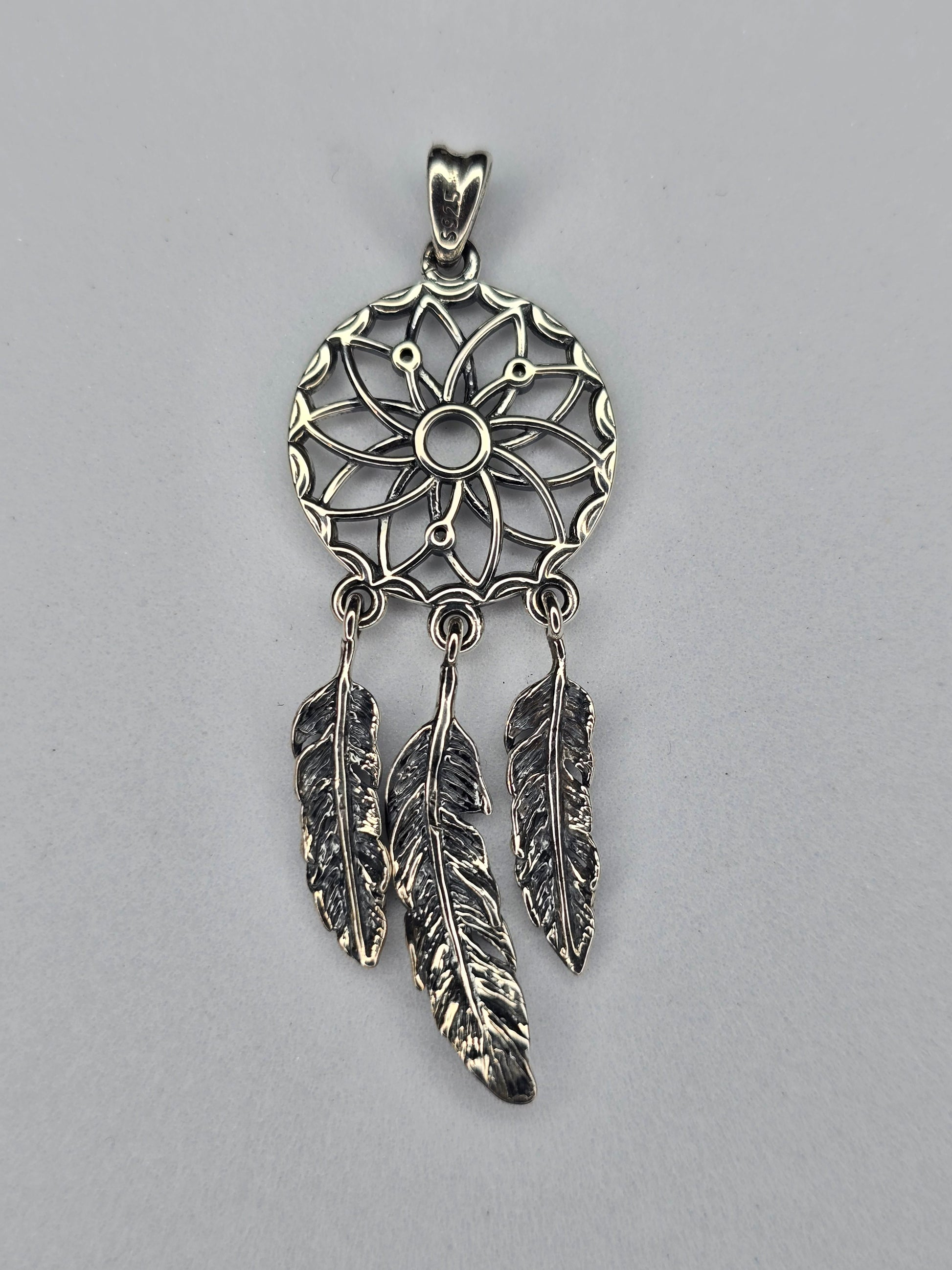 Back view of sterling silver dream catcher pendant with feather details and hallmark