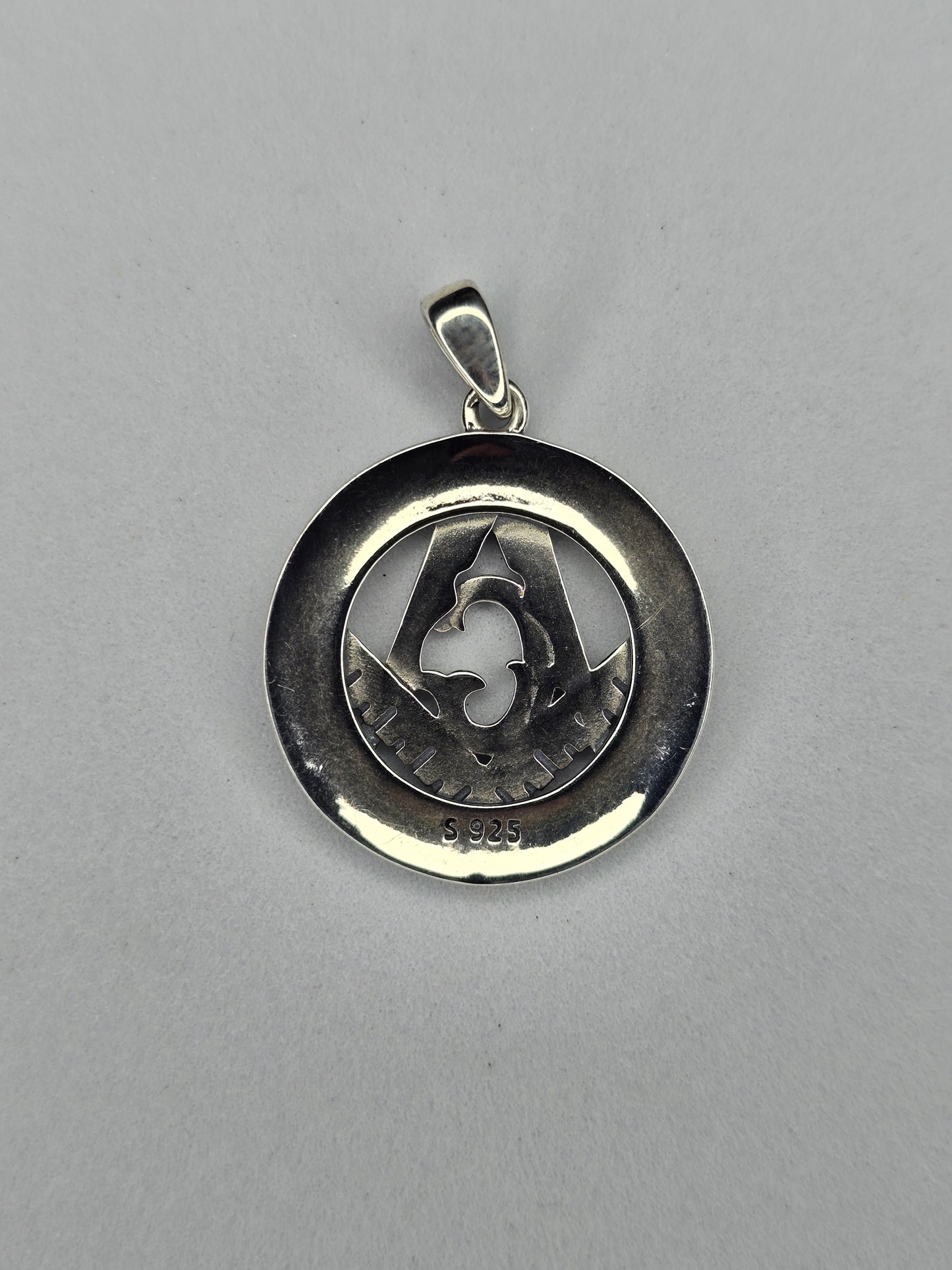 Back view of sterling silver Freemason pendant with circular polished frame and hallmark