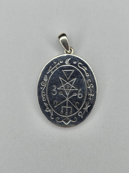 Back view of sterling silver occult pendant with engraved sigil and textured finish
