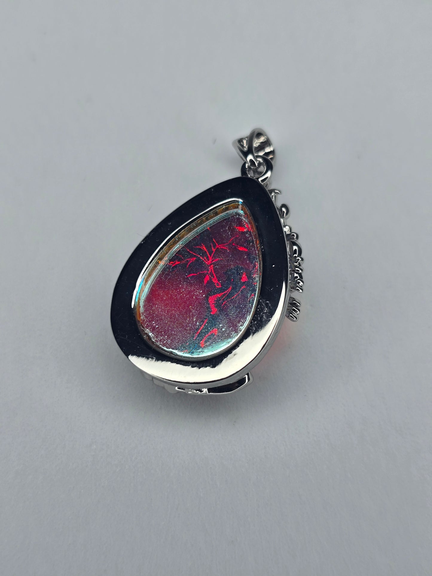 Side view of Tree of Life moonstone pendant showing teardrop silver setting and natural stone