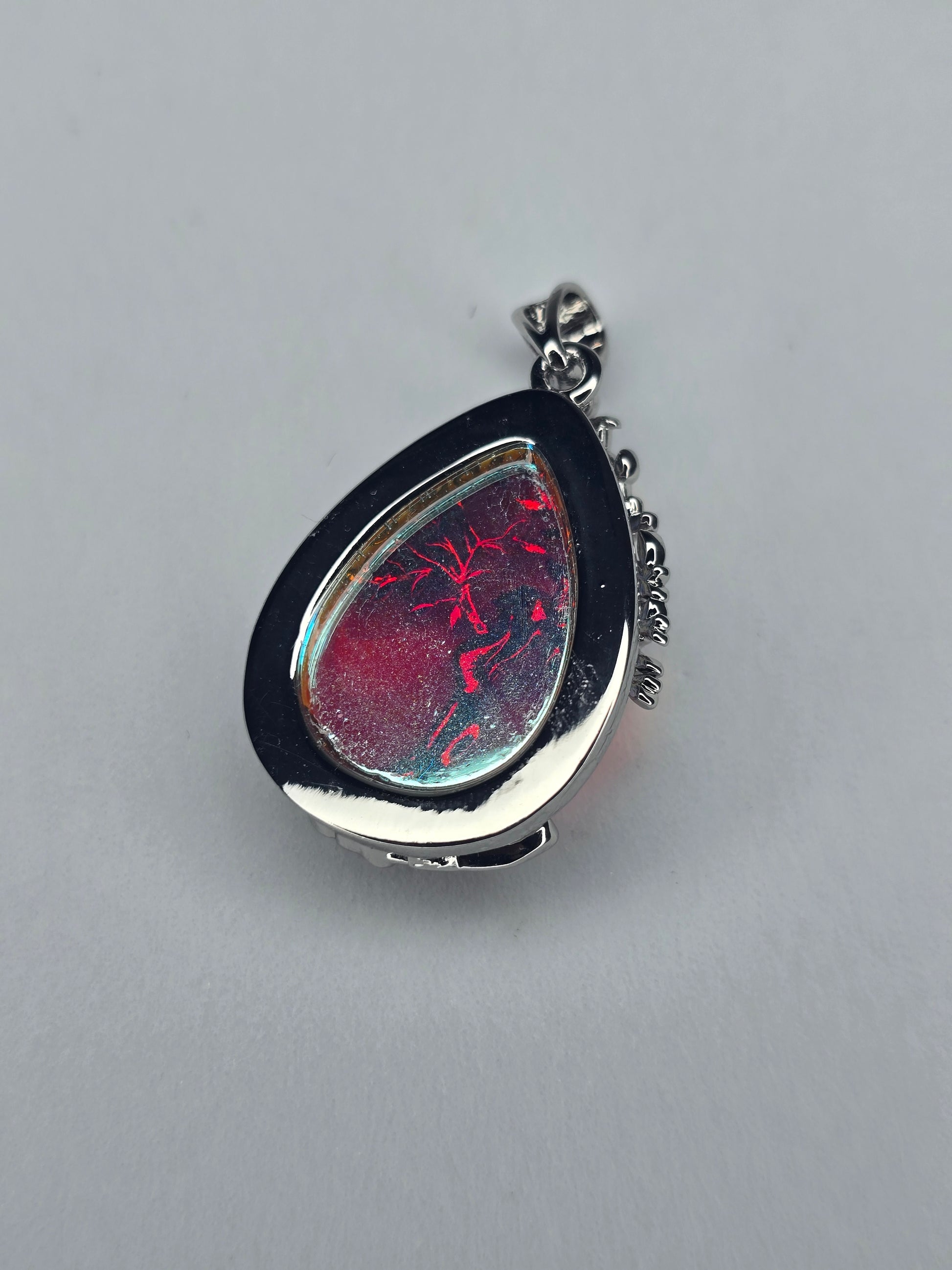 Side view of Tree of Life moonstone pendant showing teardrop silver setting and natural stone