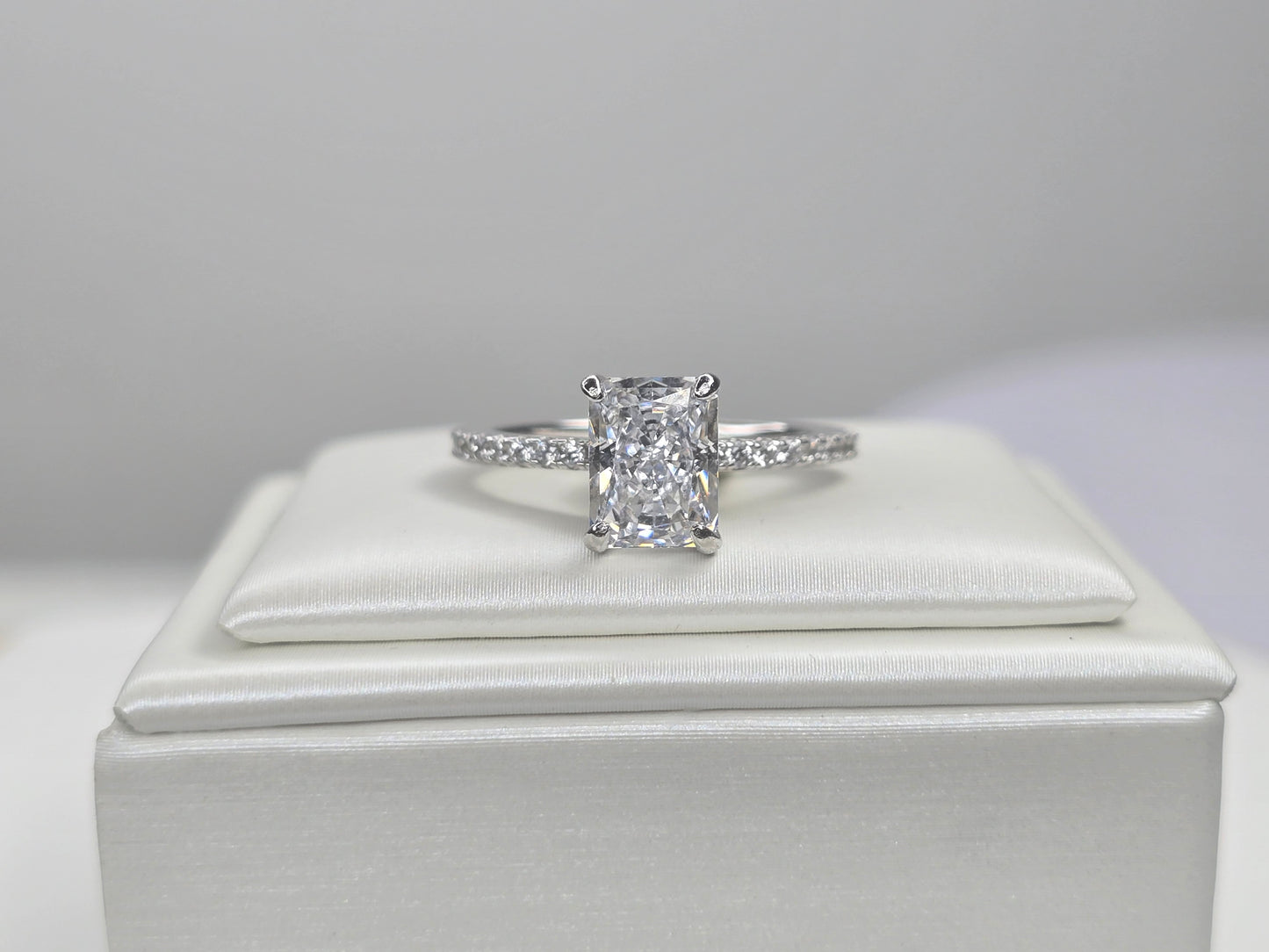 Front view of radiant cut crushed ice zircon solitaire ring on white display