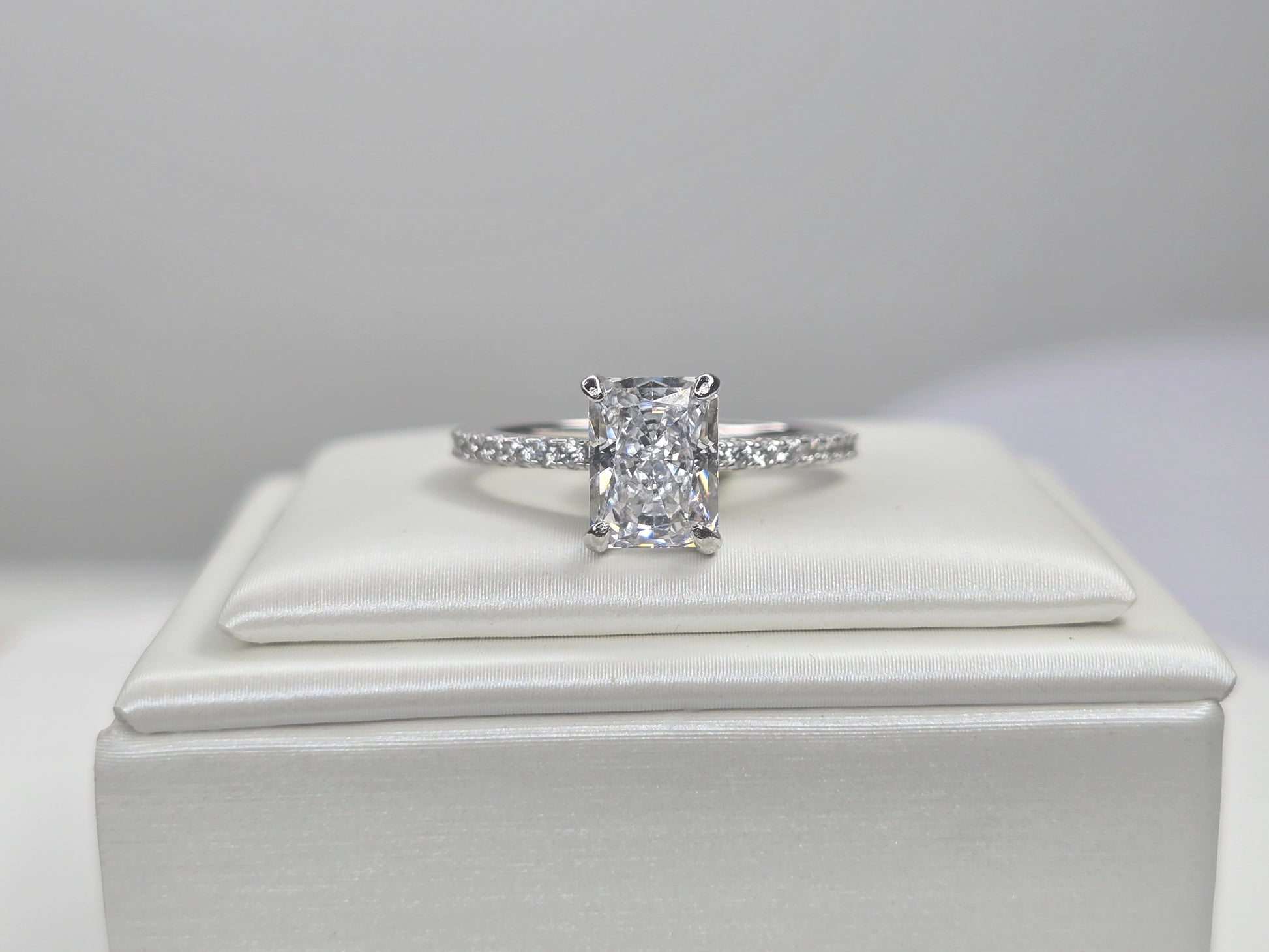 Front view of radiant cut crushed ice zircon solitaire ring on white display
